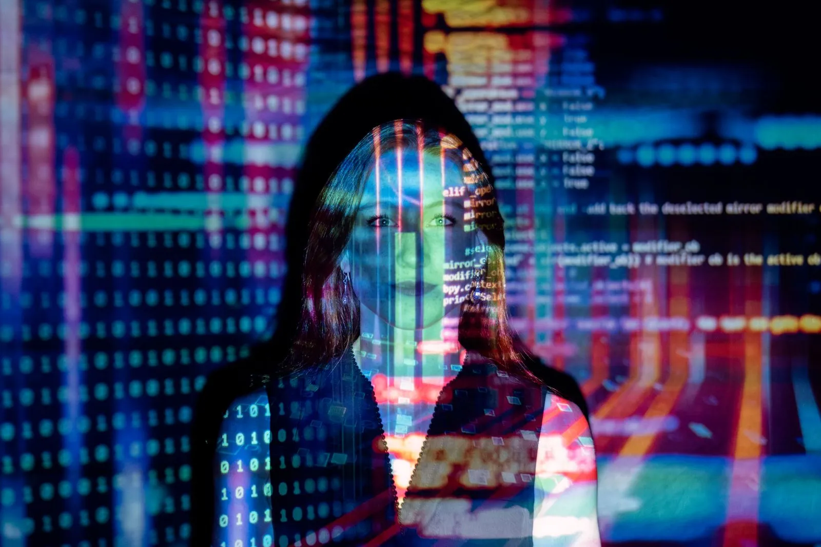 A person standing in front of a wall of projected code and coloured data