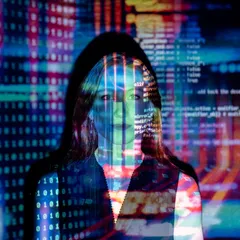 A person standing in front of a wall of projected code and coloured data