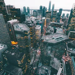 A dense city skyline beneath a bright afternoon sky