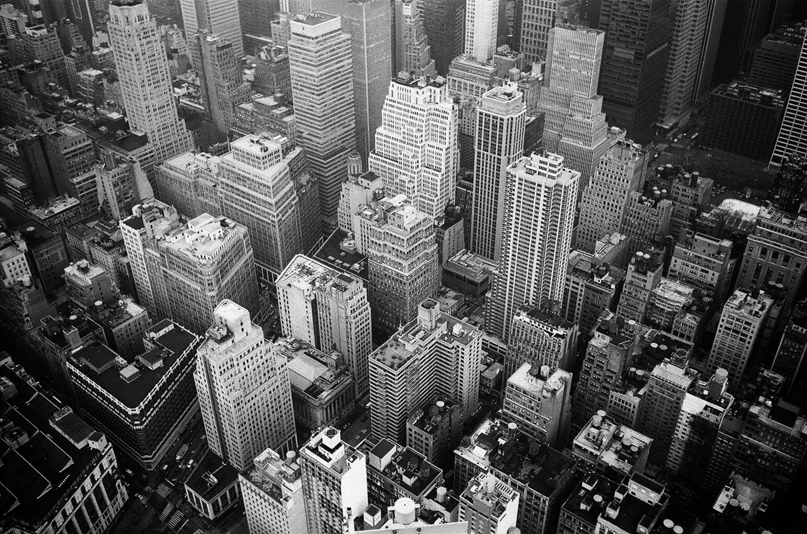 A black-and-white aerial view of dense Manhattan rooftops and skyscrapers
