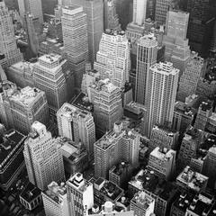 A black-and-white aerial view of dense Manhattan rooftops and skyscrapers