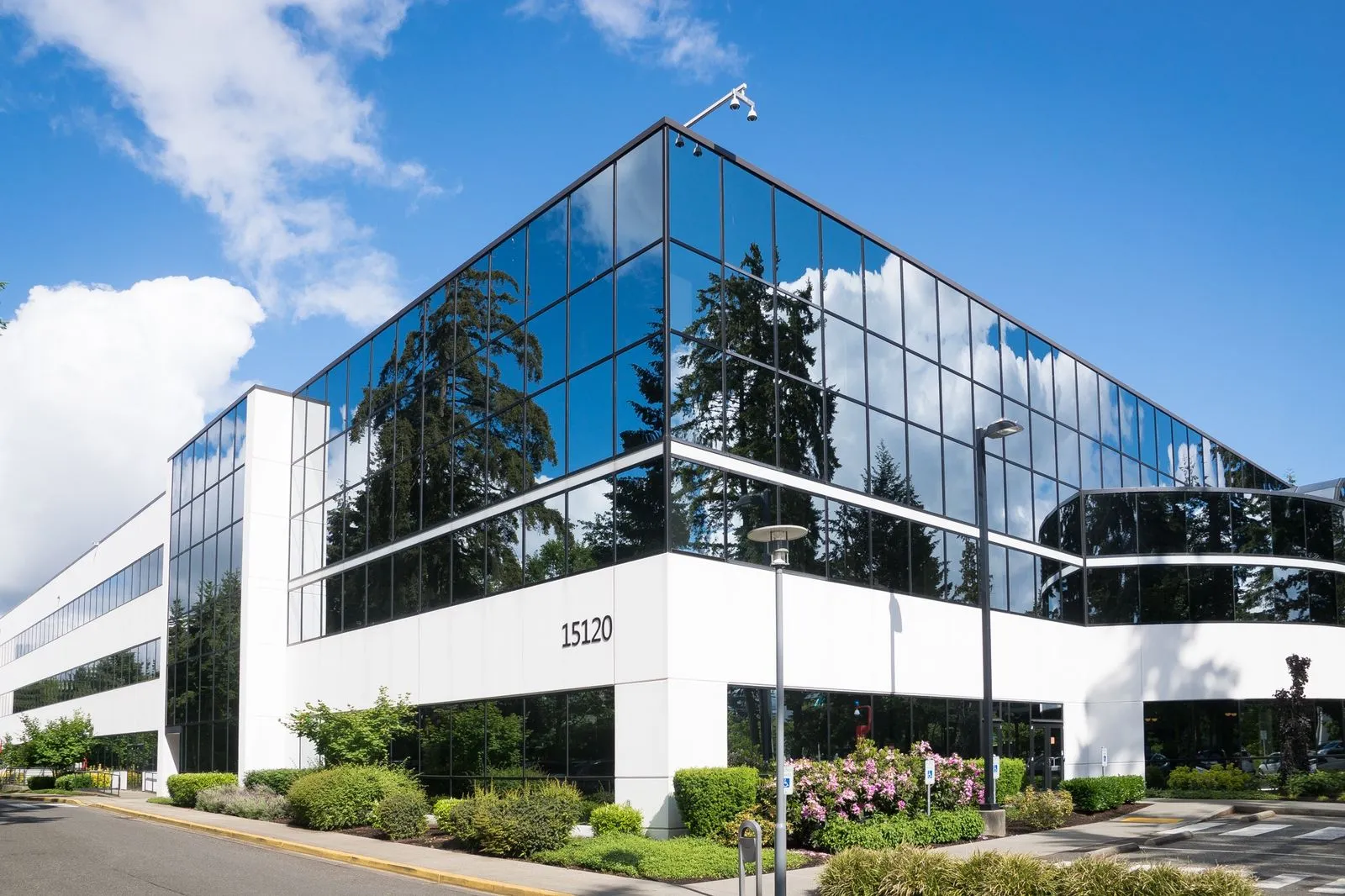 A modern glass technology building under a bright sky