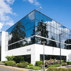 A modern glass technology building under a bright sky