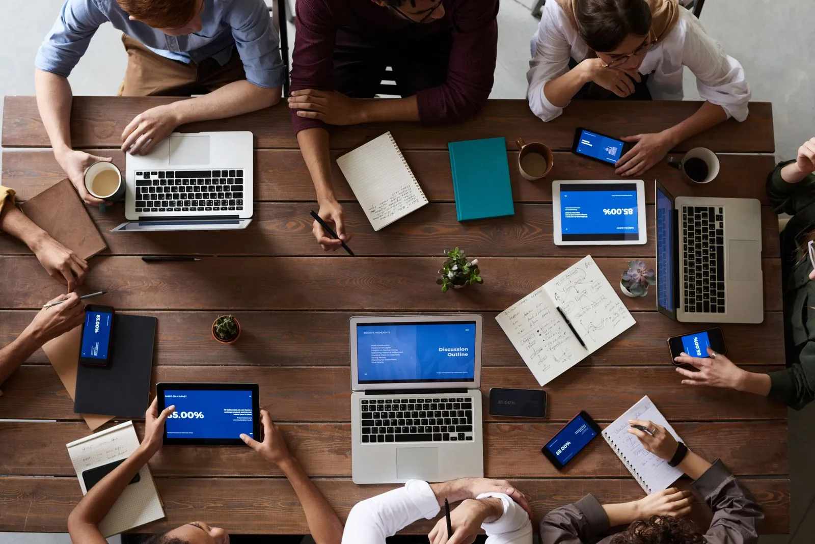 A tabletop view of laptops, notes, and phones during a policy meeting