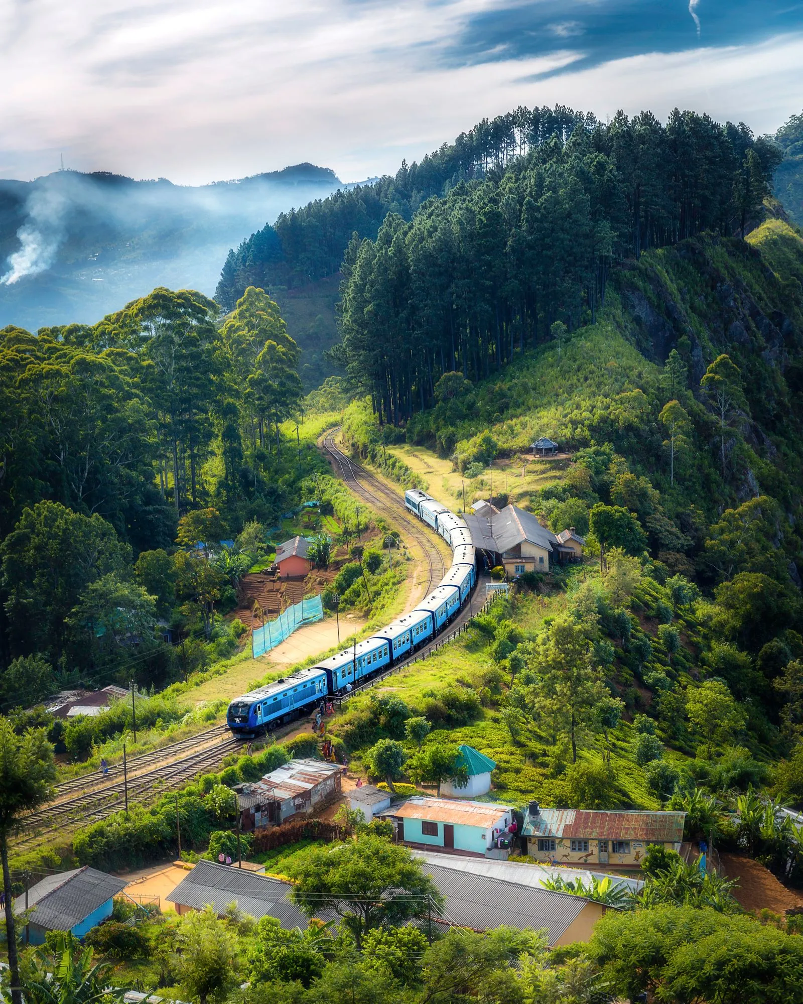 A winding road through green mountains and a river valley