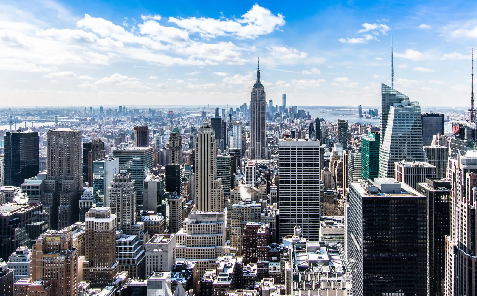 A high-rise skyline with a broadcast tower in the distance