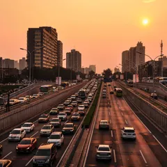 Traffic filling a multi-lane urban expressway at sunset