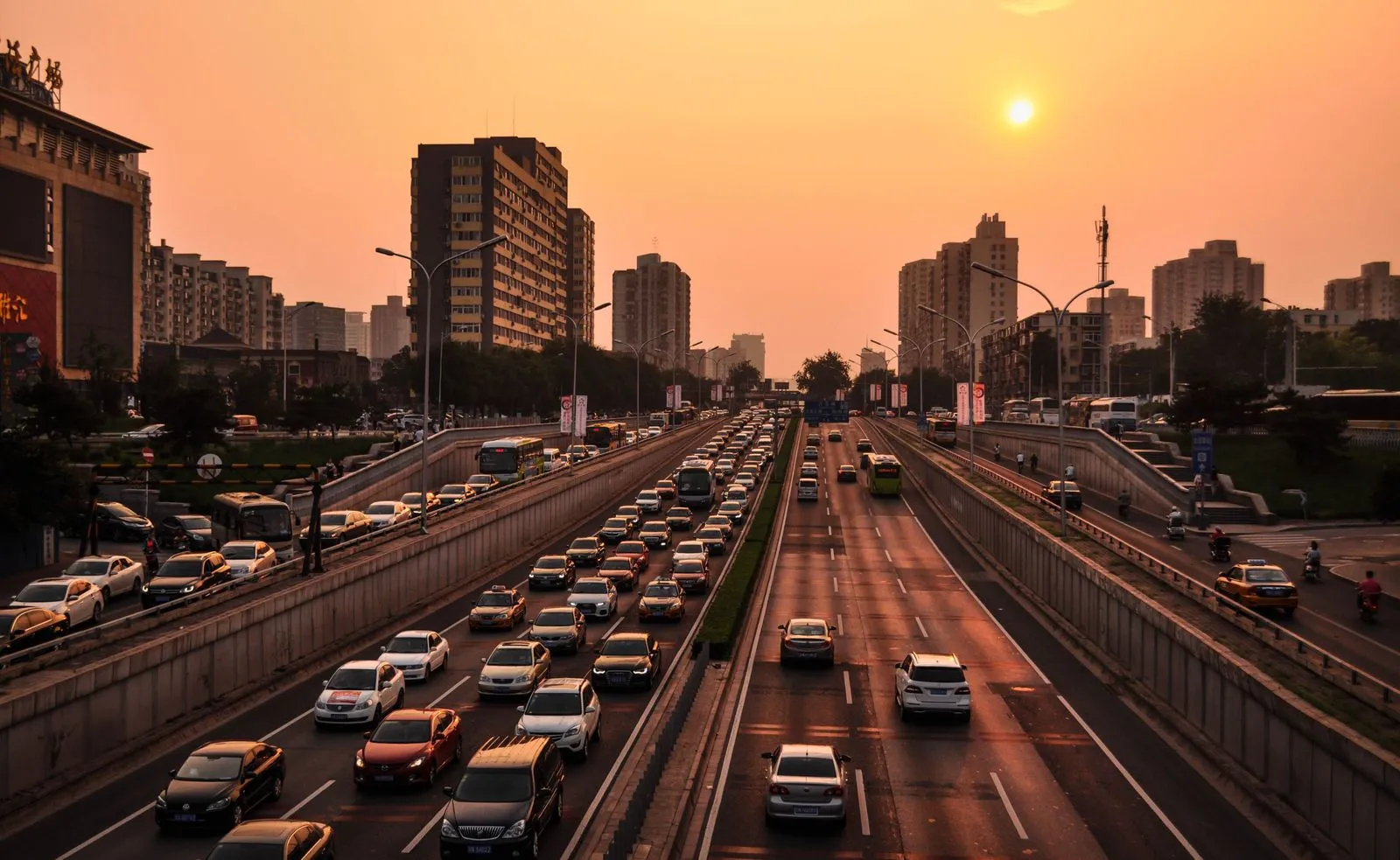 Traffic filling a multi-lane urban expressway at sunset